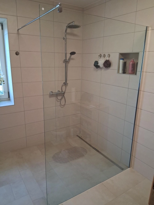 Bodengleiche Dusche mit Glastrennwand und Regenbrause