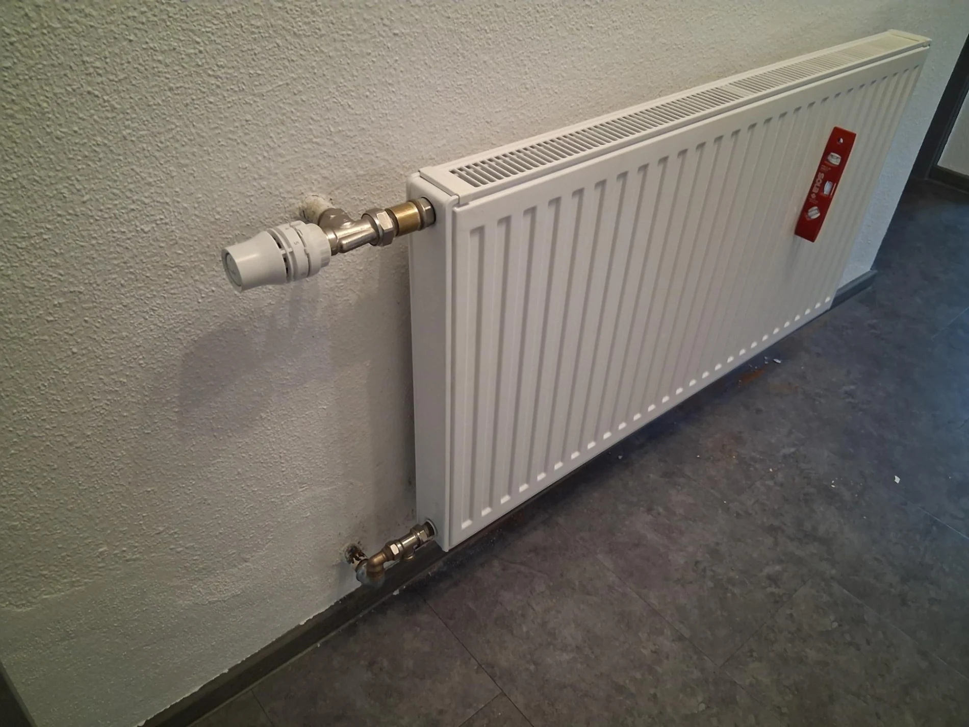 Montierter Heizkoerper mit Thermostatventil und sauberem Anschluss