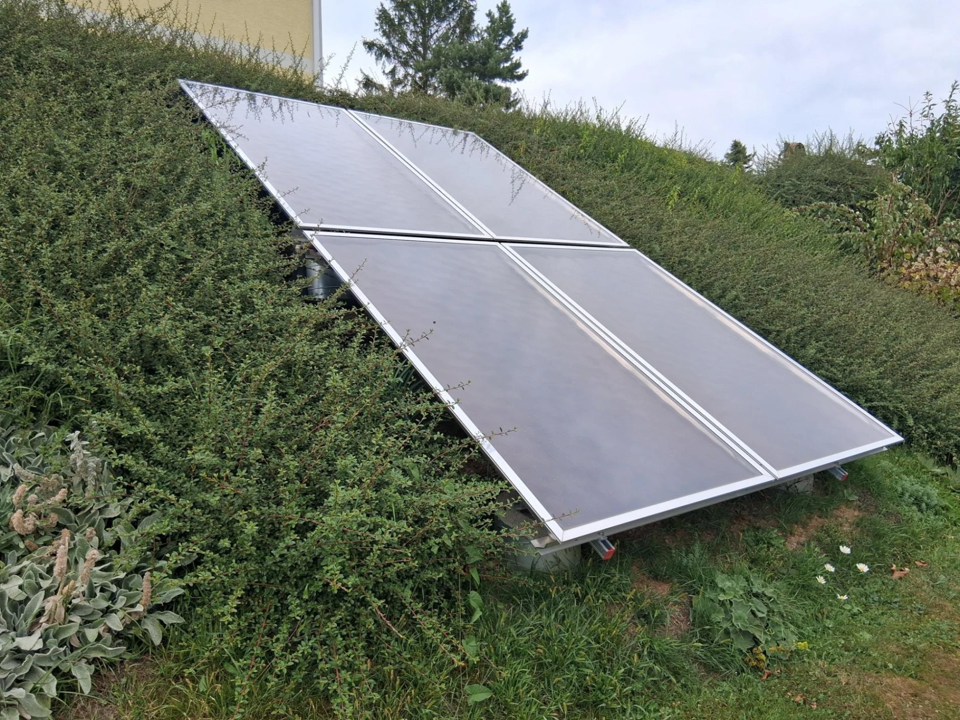 Thermische Solarkollektoren, aufgestaendert neben dem Haus